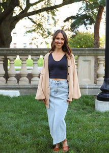 front view of model wearing the give me a reason sweater in the color caramel. model has the sweater paired with the as long as I live denim midi skirt and the stay the same top in the color black. 