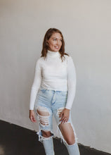 Load image into Gallery viewer, model wearing the can&#39;t get enough top in the color ivory. model has the top paired with a pair of light wash, distressed denim