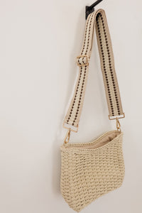 weekend getaway bag in the color cream. bag is shown with the canvas crossbody strap attached.