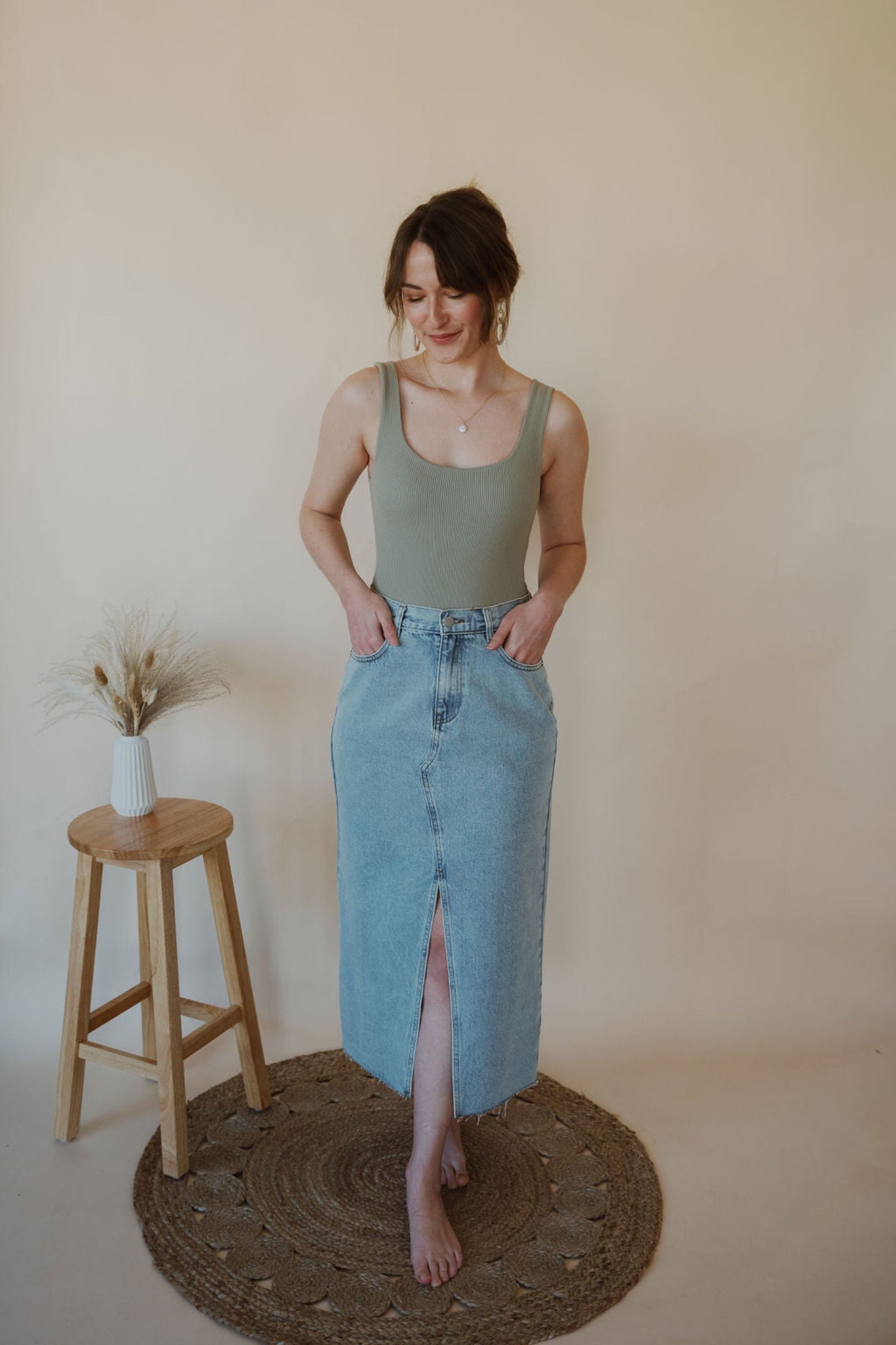 front view of model wearing the as long as I live denim midi skirt. model has the skirt paired with the used to know bodysuit in the color light moss.