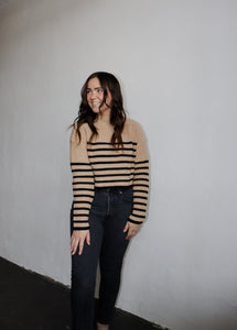 model wearing the where to start sweater. model has the sweater paired with a pair of black denim.