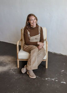 model wearing the settlin' down corduroy overalls in the color taupe. model has the overalls paired with the by your side top in the color espresso and a pair of neutral boots.