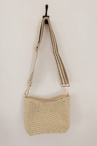 weekend getaway bag in the color cream. bag is shown with the crossbody canvas strap attached.