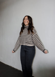 model wearing the reasons why sweater. model has the sweater paired with a pair of black denim.
