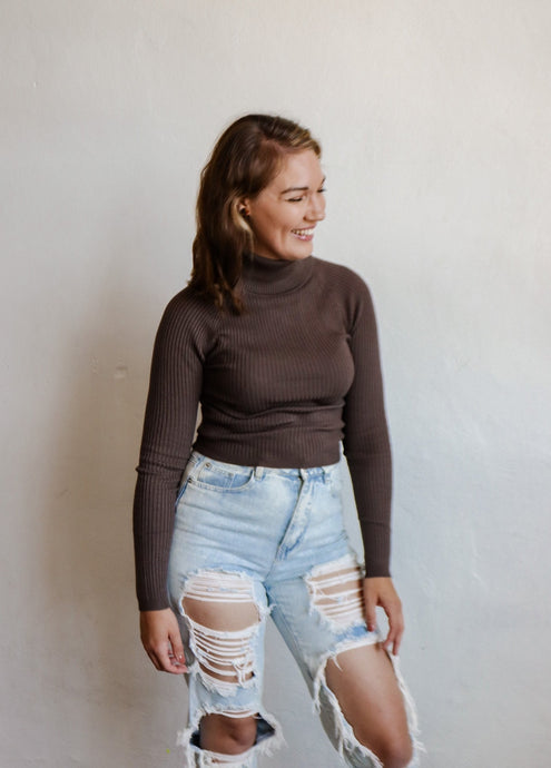 model wearing the can't get enough top in the color brown. model has the top paired with a pair of light wash, distressed denim