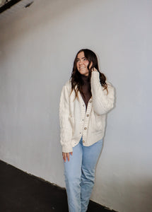 model wearing the long ago sweater. model has the sweater paired with the can't get enough top in the color brown and a pair of light wash denim.