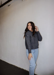 model wearing the my way back home sweater in the color charcoal. model has the sweater paired with a pair of light wash denim.