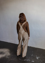 Load image into Gallery viewer, model wearing the settlin&#39; down corduroy overalls in the color taupe. model has the overalls paired with the by your side top in the color espresso and a pair of neutral boots.