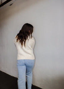 model wearing the long ago sweater. model has the sweater paired with the can't get enough top in the color brown and a pair of light wash denim.