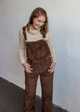 Load image into Gallery viewer, model wearing the settlin&#39; down corduroy overalls in the color brown. model has the overalls paired with the by your side top in the color taupe.