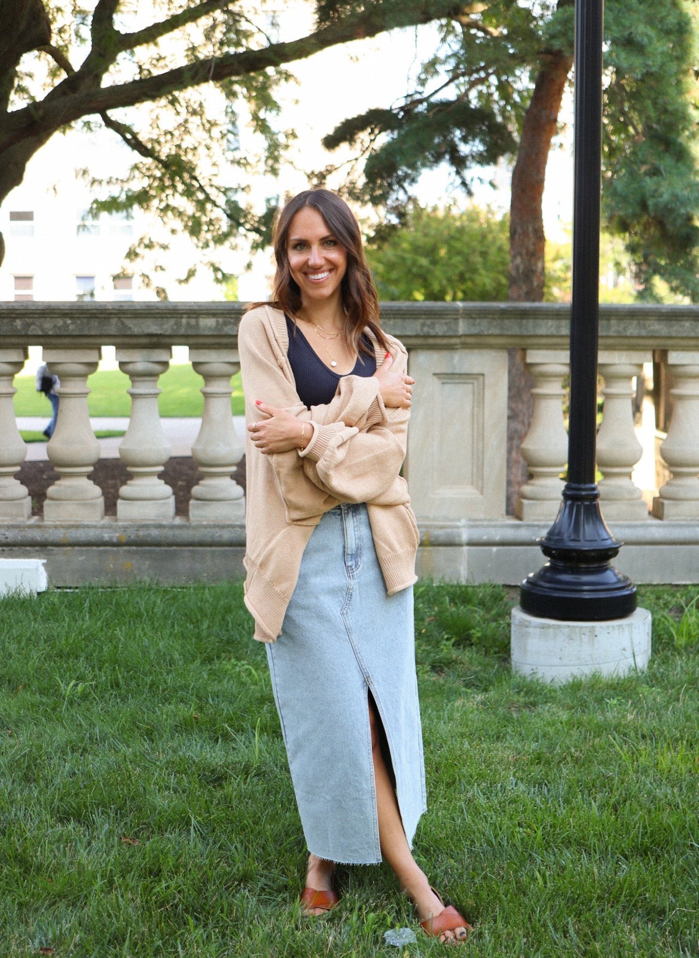 front view of model wearing the give me a reason sweater in the color caramel. model has the sweater paired with the as long as I live denim midi skirt and the stay the same top in the color black. 