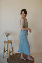 Load image into Gallery viewer, side view of model wearing the as long as I live denim midi skirt. model has the skirt paired with the used to know bodysuit in the color light moss.