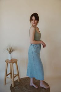 side view of model wearing the as long as I live denim midi skirt. model has the skirt paired with the used to know bodysuit in the color light moss.