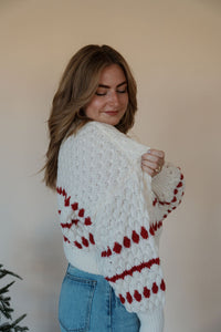 side view of model wearing the winter wonderland sweater. model has the sweater paired with the genevive denim.