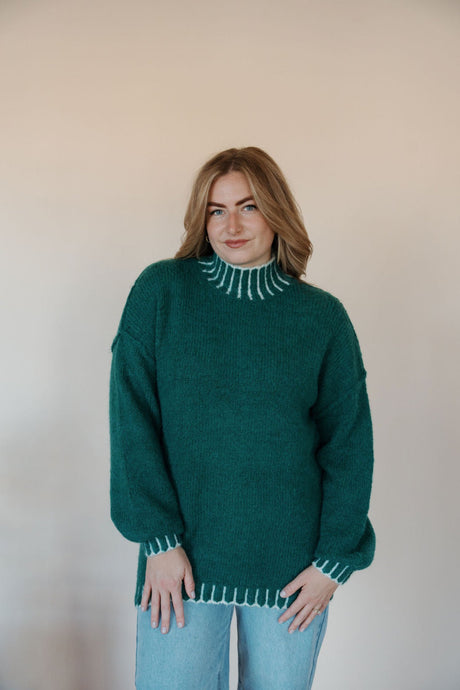 front view of model wearing the mistletoe sweater. model has the sweater paired with the genevive denim.