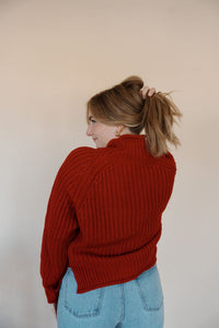 back view of model wearing the patiently waiting sweater. model has the sweater paired with the genevive denim.