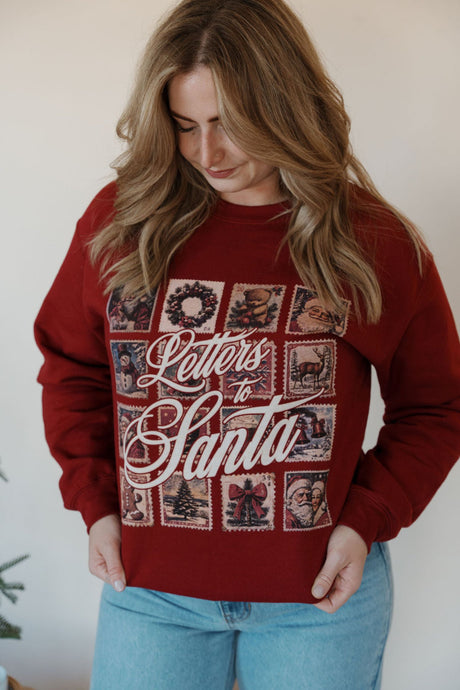 front view of model wearing the letters to santa crewneck sweatshirt. model has the sweatshirt paired with the genevive denim.