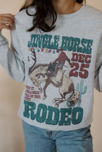 Load image into Gallery viewer, detail view of model wearing the jingle horse rodeo crewneck sweatshirt.