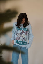 Load image into Gallery viewer, front view of model wearing the jingle horse rodeo crewneck sweatshirt.