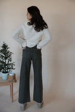 Load image into Gallery viewer, back view of model wearing the addison denim in the color fade olive. model has the denim paired with the everything to me sweater in the color cream.