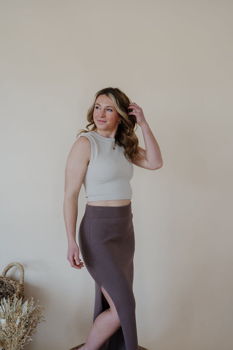 side view of model wearing the long live skirt in the color mocha. model has the skirt paired with the forever yours top in the color light beige.