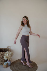 side view of model wearing the long live skirt in the color mocha. model has the skirt paired with the forever yours top in the color light beige.