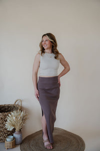front view of model wearing the long live skirt in the color mocha. model has the skirt paired with the forever yours top in the color light beige.