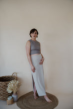Load image into Gallery viewer, side view of model wearing the long live skirt in the color champagne. model has the skirt paired with the forever yours top in the color smoky taupe. 