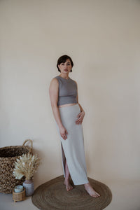side view of model wearing the long live skirt in the color champagne. model has the skirt paired with the forever yours top in the color smoky taupe. 