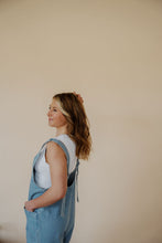 Load image into Gallery viewer, side view of model wearing the carly denim romper. model has the romper paired with the forever yours top in the color white.