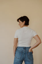 Load image into Gallery viewer, back view of model wearing the never hesitate top in the color white. model has the top paired with the aurora denim.