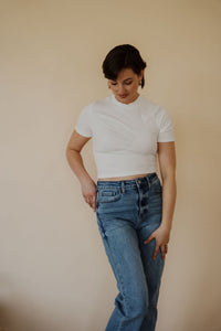 front view of model wearing the never hesitate top in the color white. model has the top paired with the aurora denim.