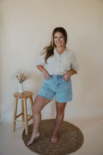 Load image into Gallery viewer, front view of model wearing the dakota denim shorts. model has the shorts paired with the out of office top in the color taupe.