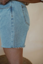 Load image into Gallery viewer, side view of model wearing the dakota denim shorts. model has the shorts paired with the out of office top in the color taupe.