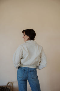 back view of model wearing the cherish the moment jacket in the color white dove. model has the jacket paired with the forever yours top in the color macchiato and the aurora denim.