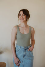 Load image into Gallery viewer, front view of model wearing the used to know bodysuit in the color light moss. model has the bodysuit paired with the as long as I live denim midi skirt.