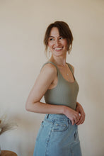 Load image into Gallery viewer, side view of model wearing the used to know bodysuit in the color light moss. model has the bodysuit paired with the as long as I live denim midi skirt.