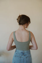 Load image into Gallery viewer, back view of model wearing the used to know bodysuit in the color light moss. model has the bodysuit paired with the as long as I live denim midi skirt.