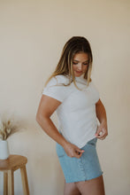 Load image into Gallery viewer, side view of model wearing the back to the basics tee in the color white. model has the top paired with the dakota denim shorts.