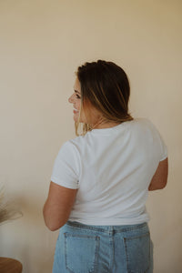 back view of model wearing the back to the basics tee in the color white. model has the top paired with the dakota denim shorts.