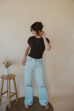 Load image into Gallery viewer, front view of model wearing the back to the basics tee in the color charcoal. model has the top paired with the camden denim.