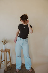 front view of model wearing the back to the basics tee in the color charcoal. model has the top paired with the camden denim.