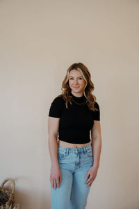 front view of model wearing the never hesitate top in the color black. model has the top paired with the charleston denim.