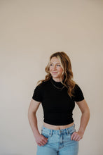 Load image into Gallery viewer, front view of model wearing the never hesitate top in the color black. model has the top paired with the charleston denim.