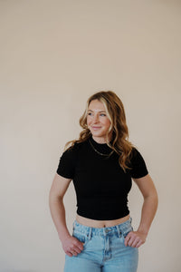 front view of model wearing the never hesitate top in the color black. model has the top paired with the charleston denim.