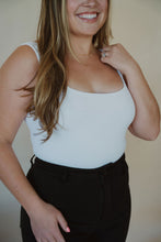 Load image into Gallery viewer, side view of model wearing the used to know bodysuit in the color white. model has the bodysuit paired with the addison denim in the color fade black.