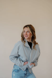 front view of model wearing the cherish the moment jacket in the color misty grey. model has the jacket paired with the never hesitate top in the color black and the charleston denim.