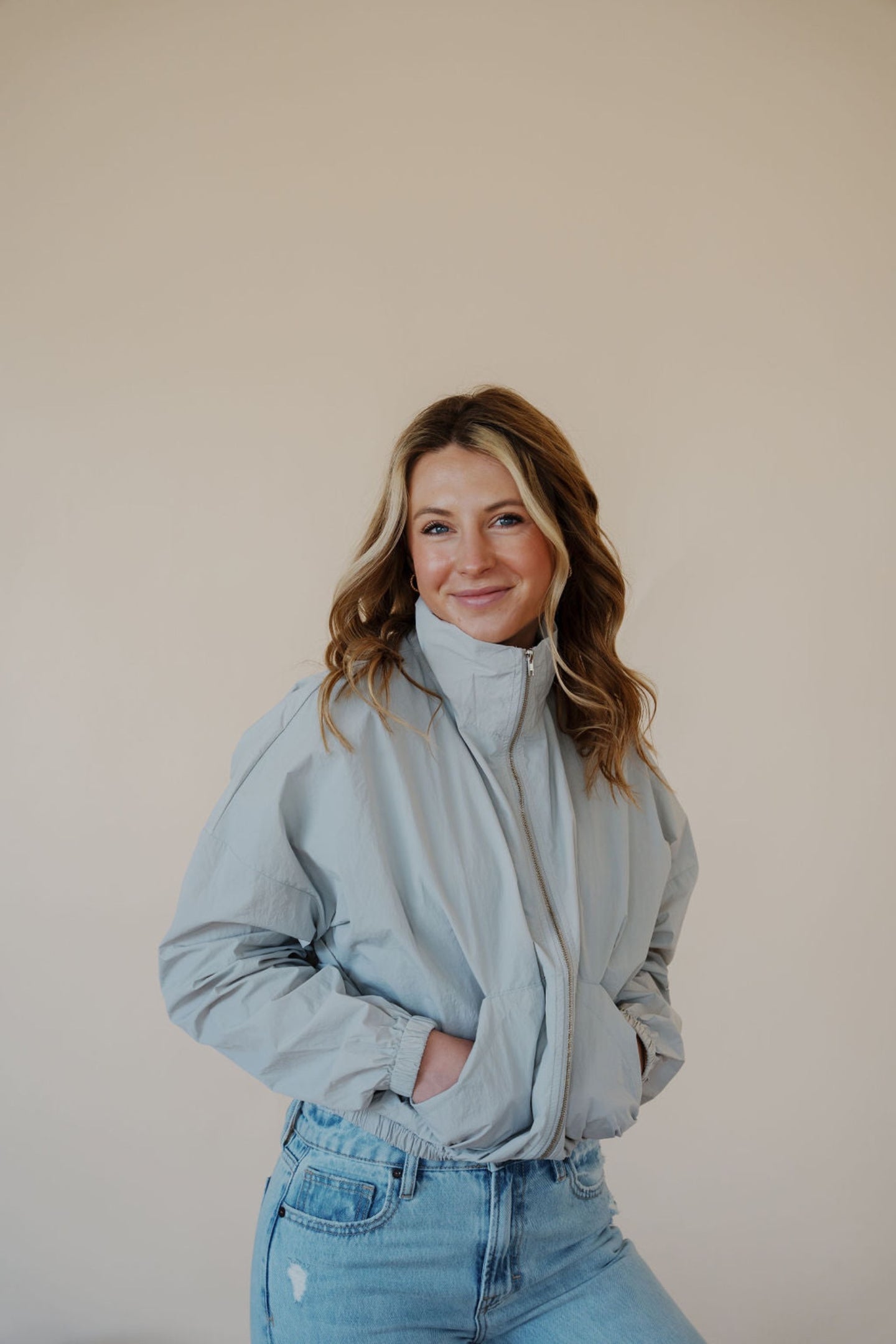front view of model wearing the cherish the moment jacket in the color misty grey. model has the jacket paired with the never hesitate top in the color black and the charleston denim.