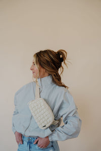 side view of model wearing the cherish the moment jacket in the color misty grey. model has the jacket paired with the never hesitate top in the color black, the no rules belt bag in beige, and the charleston denim.