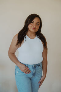 front view of model wearing the change your mind bodysuit in the color white. model has the bodysuit paired with the charleston denim.